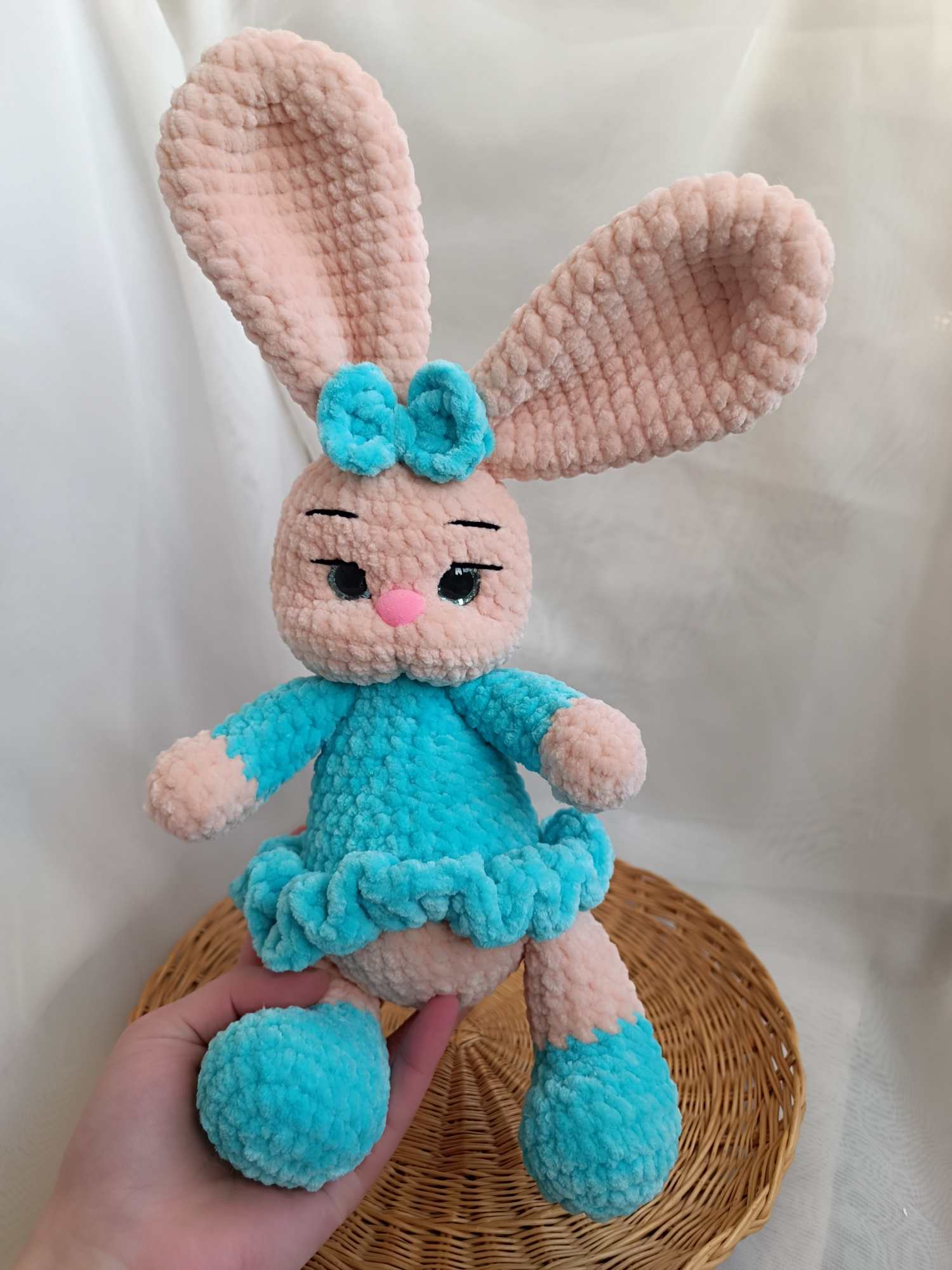 A crocheted rabbit in a blue dress