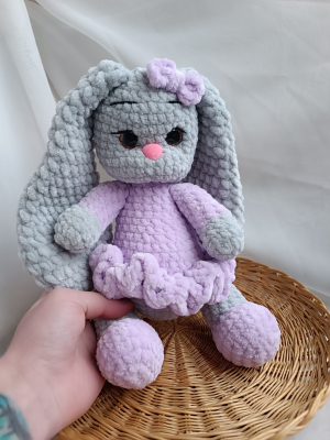 A crocheted bunny in a lilac dress